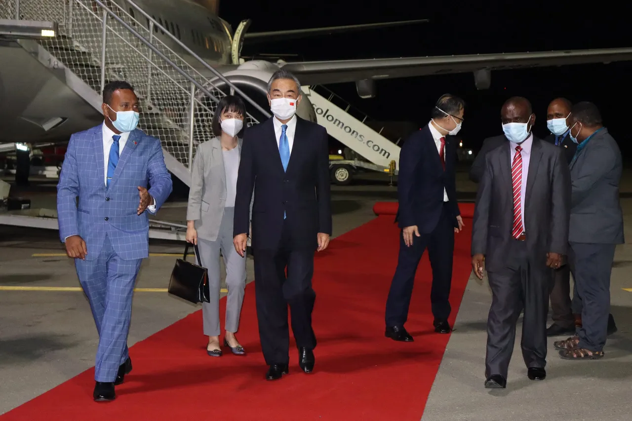 This picture taken on May 25, 2022 shows Solomon Islands' Foreign Minister Jeremiah Manele (R) and Chief Protocole Walter Diamana (L) escorting Chinese Foreign Minister Wang Yi (C) upon his arrival at the Henderson International Airport in Honiara. (Photo by STRINGER/AFP via Getty Images)