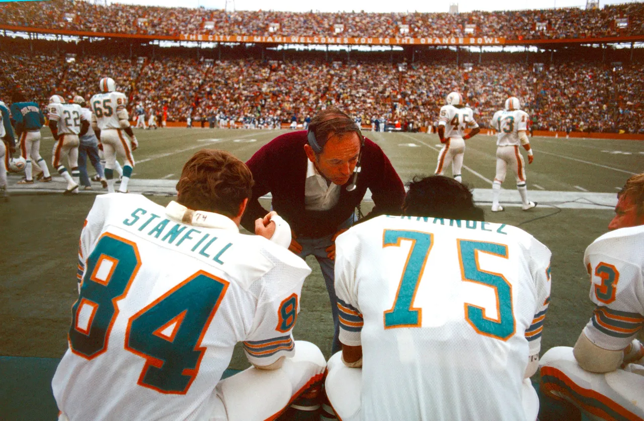 MIAMI, FLORIDA - DECEMBER 16: Bill Arnsparger, Defensive Coordinator of the Miami Dolphins, speaks with Bill Stanfill, Defensive End, and Manny Fernandez, Defensive Tackle, during an NFL Football game against the Baltimore Colts, December 16, 1972. (Photo by Ross Lewis/Getty Images)