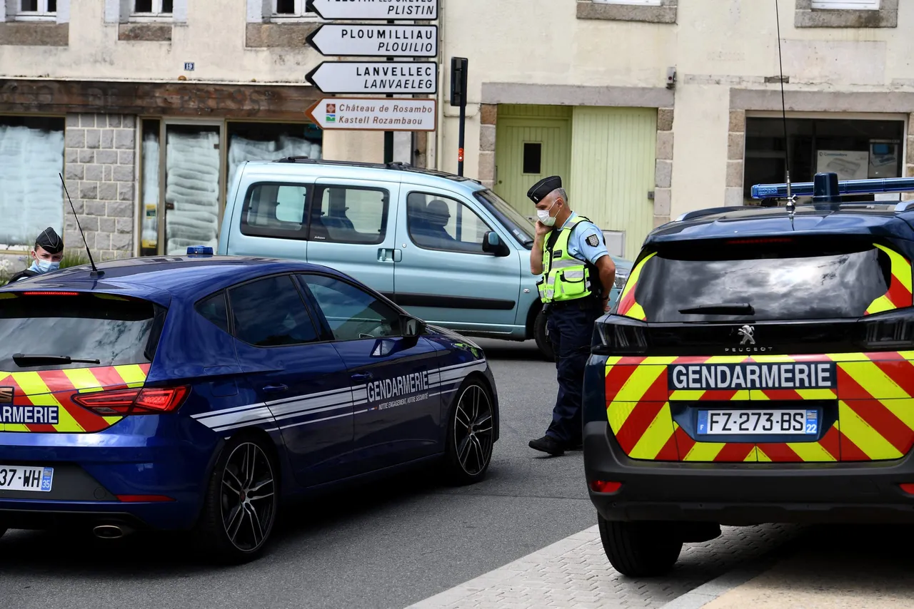 A French gendarme (C) speaks on a telephone at a traffic intersection in Plouaret, western France on July 31, 2021, whilst conducting an investigation to find the father of an eight-year-old missing child 'Dewi', who was allegedly taken on July 30. (Photo by FRED TANNEAU/AFP via Getty Images)
