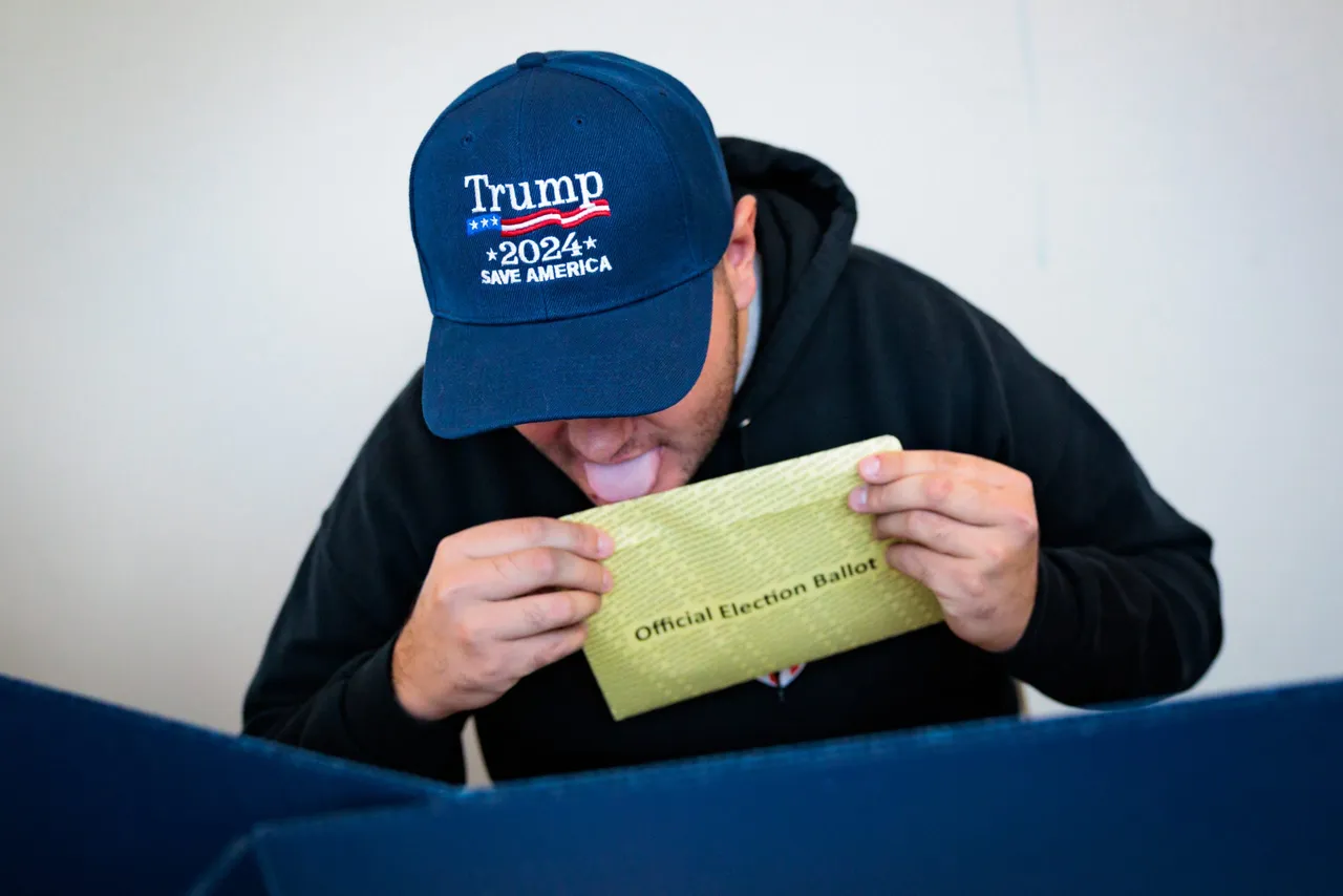 DOYLESTOWN, PENNSYLVANIA - OCTOBER 15: Kenny Laureno, 24, seals their official election ballot while voting "On Demand" using an absentee or mail-in ballot on October 15, 2024 in Doylestown, Pennsylvania. Registered voters in Pennsylvania can vote "On Demand" by requesting, a mail-in or absentee ballot filing it out and dropping it off all in one visit to their county election office or other designated location. (Photo by Hannah Beier/Getty Images)