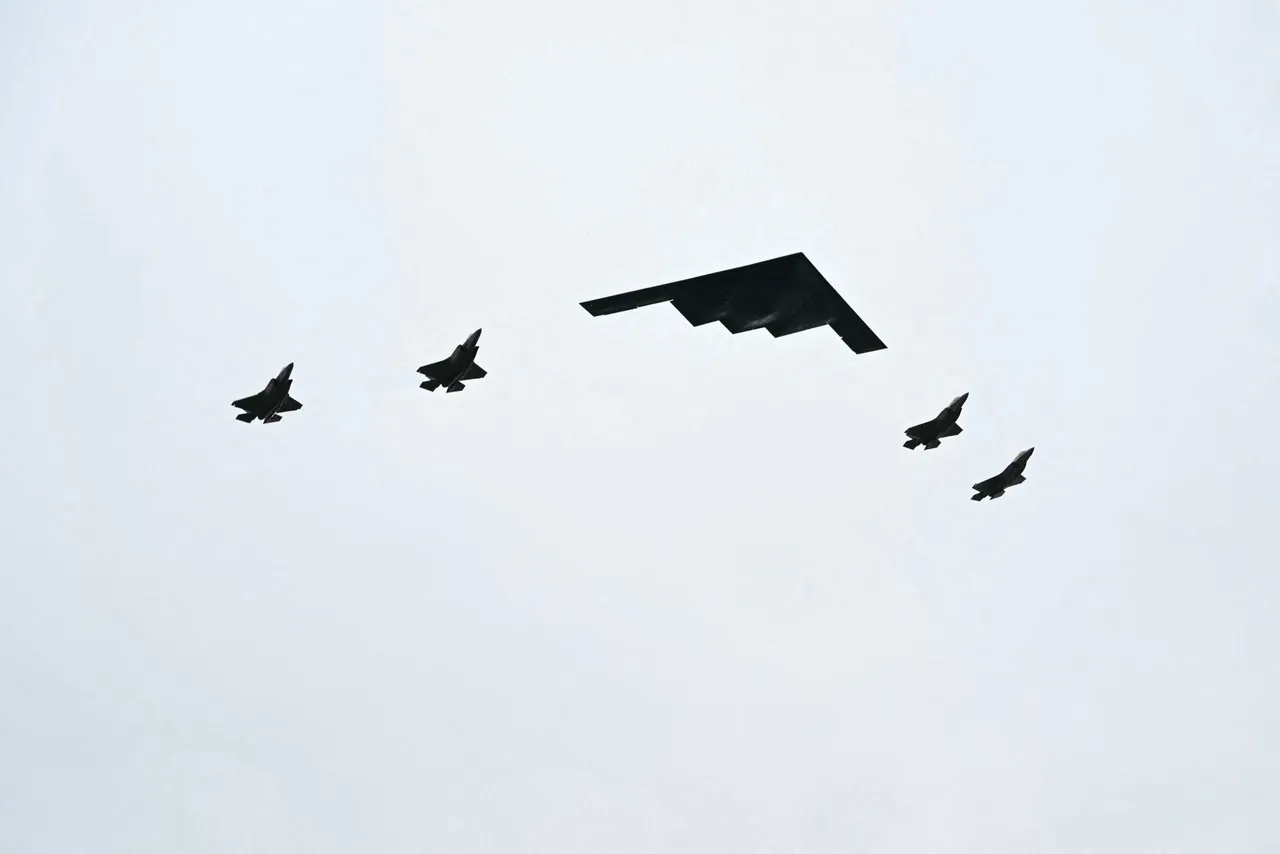 A B-2 bomber (C) and four F-35 fighter jets fly overhead as US President Donald Trump greets Russian President Vladimir Putin on the tarmac after they arrived at Joint Base Elmendorf-Richardson in Anchorage, Alaska, on August 15, 2025. (Photo by ANDREW CABALLERO-REYNOLDS / AFP via Getty Images)