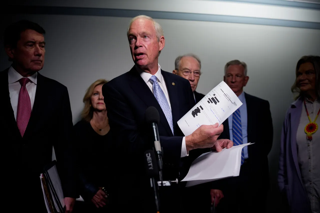 Sen. Ron Johnson (R-WI) holds up documents as he speaks to reporters on Capitol Hill