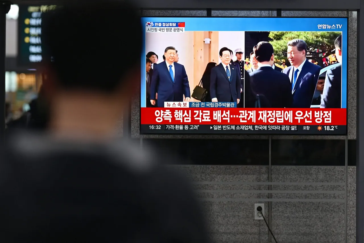 A television screen at a train station in Gyeongju on November 1, 2025 shows a news broadcast of South Korea's President Lee Jae Myung with China's President Xi Jinping during a welcoming ceremony as part of the Asia-Pacific Economic Cooperation (APEC) Summit. (Photo by ANTHONY WALLACE/AFP via Getty Images)
