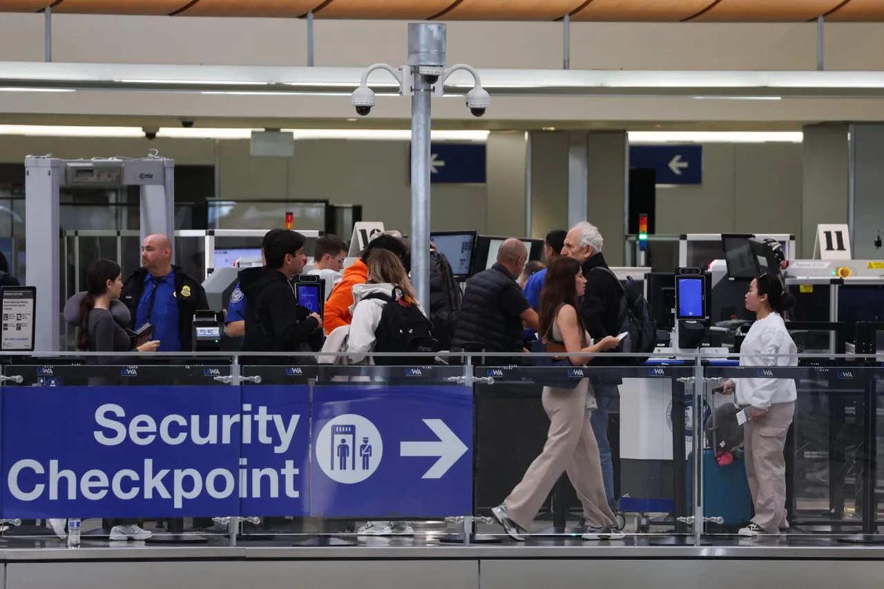 TSA agents screen passengers as travelers wait for passenger screening at a Transportation Security Administration (TSA) checkpoint inside the Tom Bradley International Terminal (TBIT) at Los Angeles International Airport (LAX) in Los Angeles, California on March 23, 2026. (Photo by Patrick T. Fallon / AFP via Getty Images)