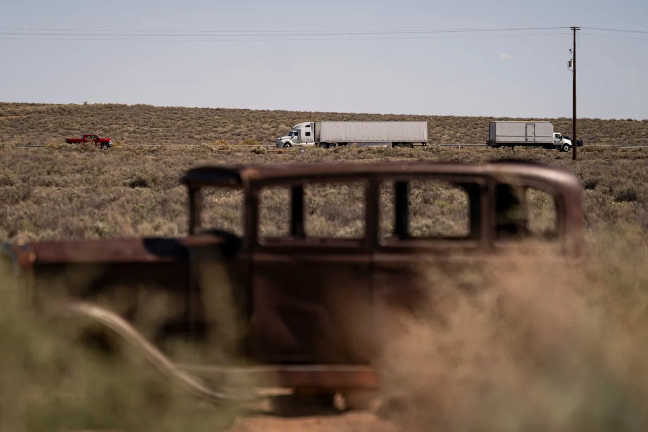 A tractor trailer travels on Interstate 40 (I-40) near a 1932 Studebaker sitting alongside the original 19261958 path of the historic Route 66 at Petrified Forest National Park on April 17, 2026 in Arizona. (Photo by Al Drago/Getty Images)