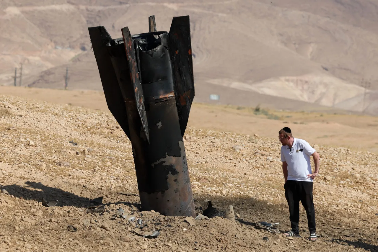 A man checks a fallen rocket half-buried in the ground on the outskirts of Jericho on June 8, 2026, following Iranian and Iran-backed Houthi rebel attacks.(Photo by Ahmad GHARABLI / AFP via Getty Images)