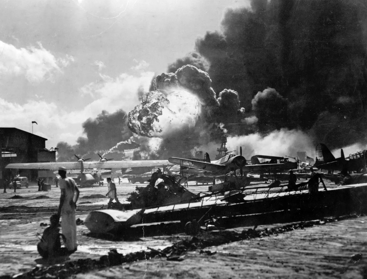 U.S. Sailors stand amid wreckage watching as the USS Shaw explodes December 7, 1941 on Ford Island, Pearl Harbor, Hawaii during the Japanese attack. (Photo by Getty Images)