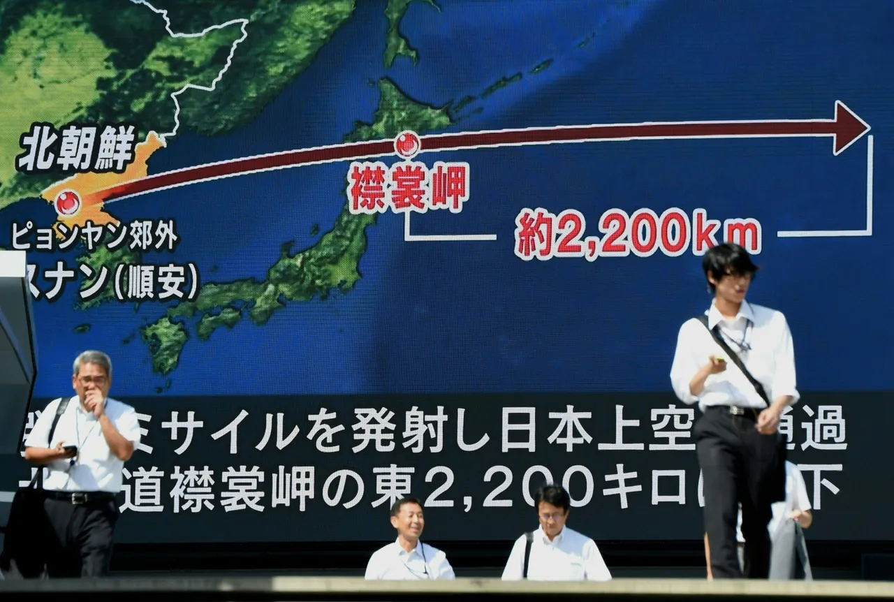 Pedestrians walk in front of a large video screen in Tokyo broadcasting a news report about North Korea's latest missile test that passed over Japan on September 15, 2017. North Korea fired a ballistic missile over Japan and into the Pacific on September 15, responding to new UN sanctions with what appeared to be its furthest-ever missile flight amid high tensions over its weapons programmes. (TORU YAMANAKA/AFP via Getty Images)