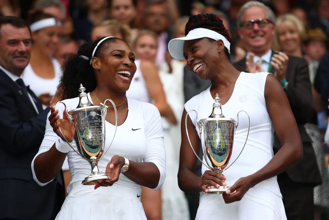 LONDON, ENGLAND - JULY 09: Venus Williams and Serena Williams of The United States hold their trophies (Photo by Clive Brunskill/Getty Images)