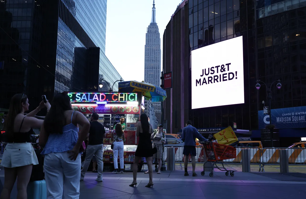 The Empire State Building is seen in the distance as people take photos of a giant screen showing the message "JUST&T MARRIED!" (T&T for Taylor and Travis) outside Madison Square Garden, the reported venue for the wedding celebrations of pop singer Taylor Swift and pro-athlete Travis Kelce, in New York City on July 3, 2026. US pop queen Taylor Swift and NFL star Travis Kelce, whose lavish wedding has drawn hundreds of celebrities to New York, have officially married, a representative for the singer said July 3. "Taylor and Travis did not have bridesmaids or groomsmen. Instead, her brother Austin Swift served as Taylor's Man of Honor and Jason Kelce was Travis's Best Man," Swift's longstanding publicist Tree Paine said in a statement. (Photo by CHARLY TRIBALLEAU / AFP via Getty Images)
