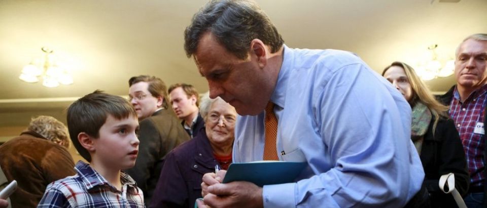 U.S. Republican presidential candidate and New Jersey Governor Chris Christie signs a notebook for Ethan Long, 8, of Nashua, New Hampshire, at a campaign town hall meeting in Merrimack, New Hampshire January 3, 2016. REUTERS/Katherine Taylor