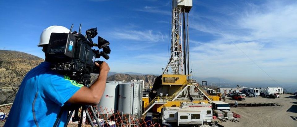 A TV cameraman works as crews from Southern California Gas Company and outside experts work on a relief well at the Aliso Canyon gas field above the Porter Ranch section of northwest Los Angeles