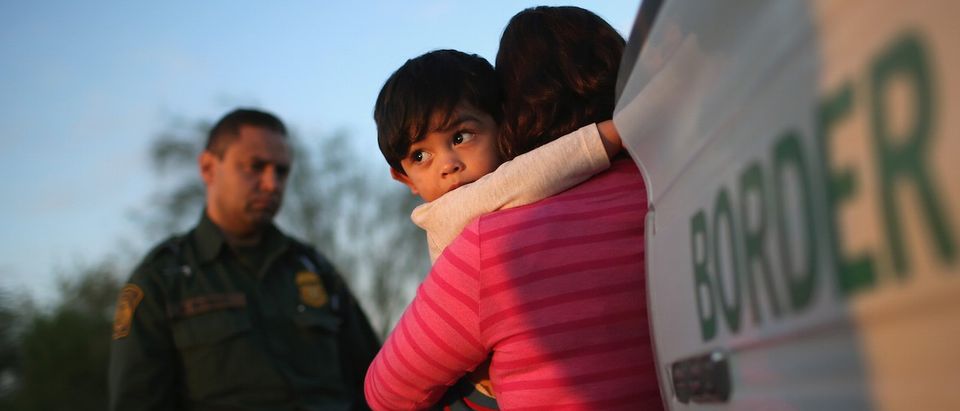A one-year-old from El Salvador clings to his mother after she turned themselves in to Border Patrol agents on December 7, 2015 near Rio Grande City, Texas. (John Moore/Getty Images)