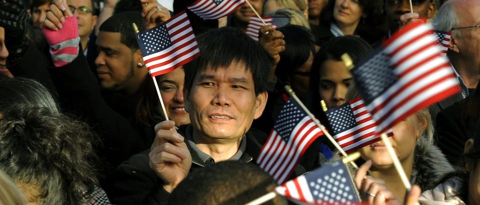 New citizens wave US flags before being sworn in during a Naturalization Ceremony conducted to swear in 125 new citizenship candidates at a ceremony on Liberty Island on October 28, 2011 to commemorate the 125th anniversary of the dedication of the Statue of Liberty. (TIMOTHY A. CLARY/AFP/Getty Images)