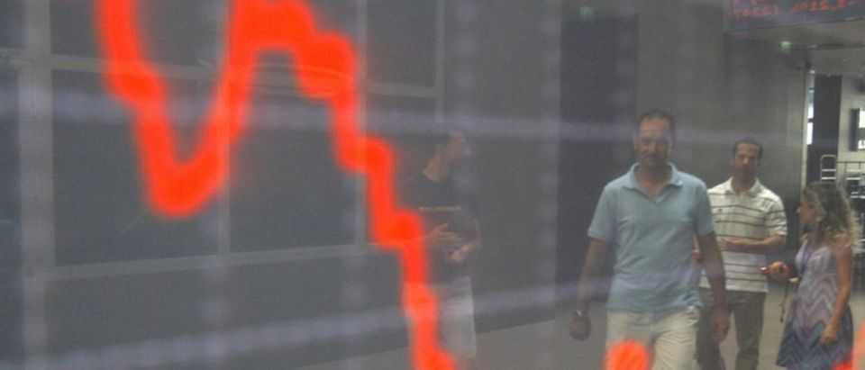 People are reflected at an index board inside the Athens stock exchange August 9, 2011. The global economy stumbled deeper into crisis as stock markets slumped further on Tuesday, with investors losing confidence that the United States and Europe can rein in their debt burdens quickly and avert a double-dip recession. REUTERS/Yiorgos Karahalis