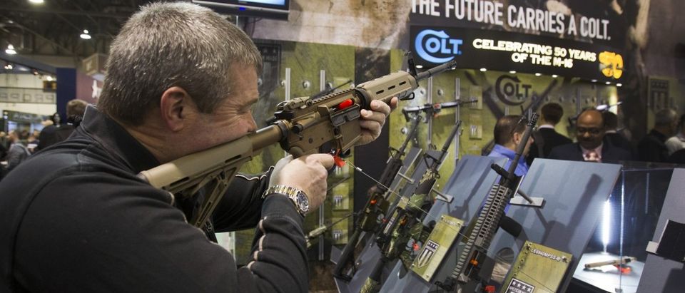 Mark Heitz of Tactical Firearms, looks over civilian version of Colt M4 carbine during SHOT Show in Las Vegas