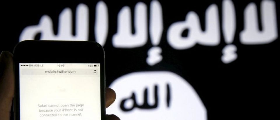 An unloaded Twitter website is seen on a phone without an internet connection, in front of a displayed ISIS flag in this photo illustration in Zenica, Bosnia and Herzegovina