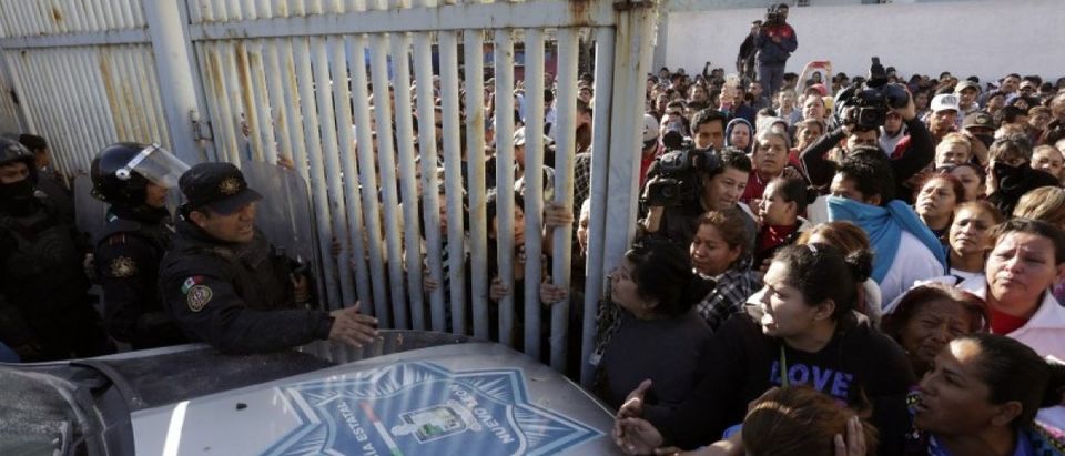 Family members of inmates argue with police at the entrance of the Topo Chico prison in Monterrey