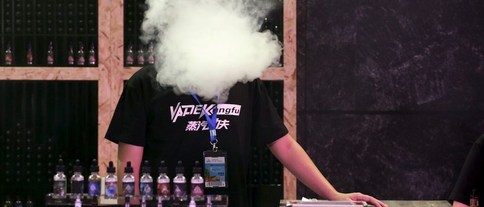 An exhibitor staff member uses an electronic cigarette at VAPE CHINA EXPO in Beijing. (REUTERS/Jason Lee)
