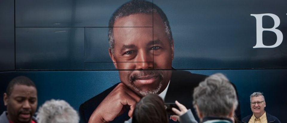 Supporters of Dr. Ben Carson stand near his book tour bus in Ames, Iowa