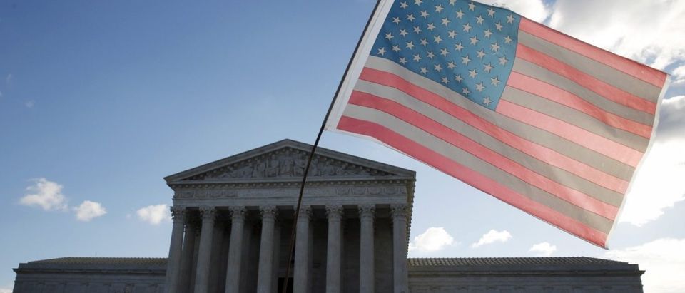 A protester holds up a flag in front of the U.S. Supreme Court in Washington