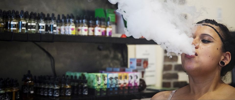 A sales clerk exhales vapor while smoking with a vaporizer during a wait for customers at the e-cigarette shop Henley Vaporium in New York, June 23, 2015. REUTERS/Lucas Jackson