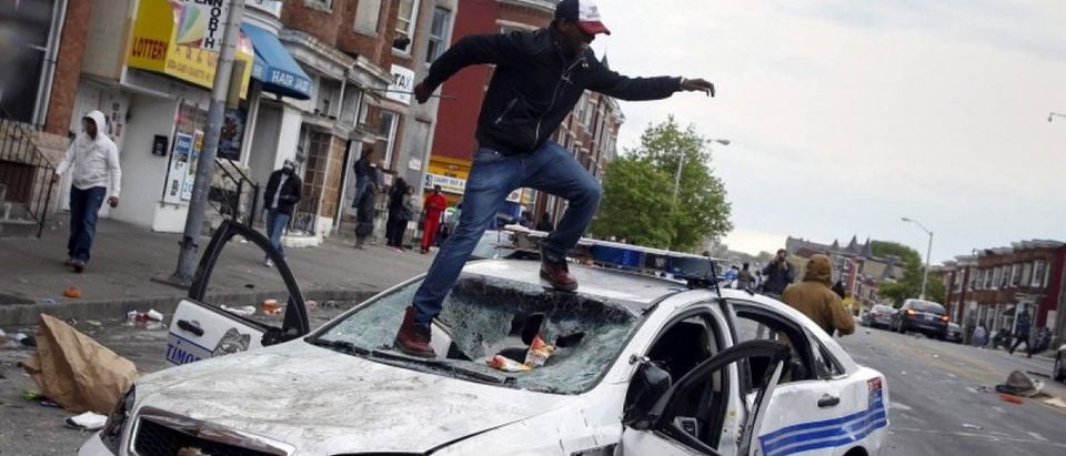 Demonstrators jump on a damaged Baltimore police department vehicle during clashes in Baltimore, Maryland, in this file photo taken April 27, 2015. REUTERS/Shannon Stapleton