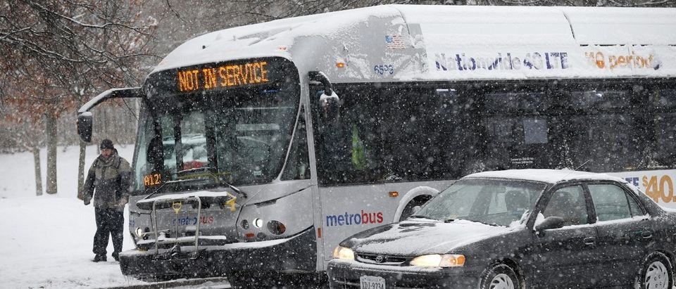 A man steps from a bus with a "no service" sign after it was immobilized by snow and ice on Wilson Boulevard in Arlington, Virginia January 6, 2015. REUTERS/Kevin Lamarque