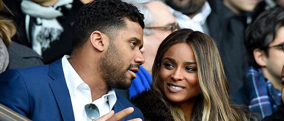 The Seattle Seahawks' quarterback Russell Wilson (L) speaks to his girlfriend singer Ciara during the French L1 football match between Paris Saint-Germain (PSG) and Montpellier (MHSC) on March 5, 2016, at the Parc des Princes stadium in Paris