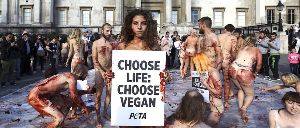 A naked woman poses for photographs as around 100 People for the Ethical Treatment of Animals (PETA) supporters gathered to lay nearly nude in a heap in Trafalgar Square to raise awareness on World Vegan Day in London November 1, 2014. REUTERS/Paul Hackett