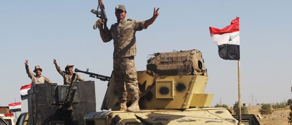Iraqi security forces members gesture near Falluja, Iraq