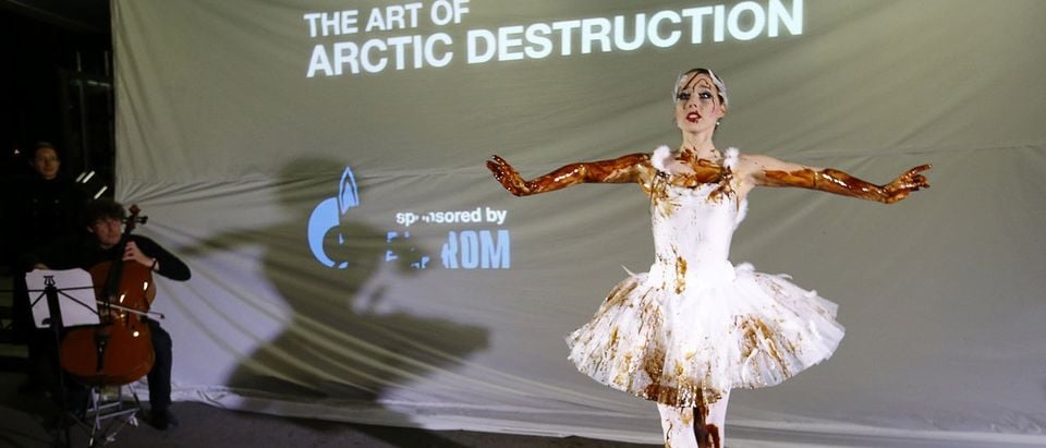 A member of Greenpeace is covered in mock oil made from molasses as she performs an interpretation of the ballet the Dying Swan during a protest in front of the Tonhalle concert hall in Zurich