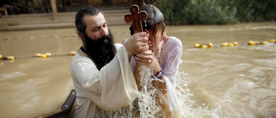 A Christian pilgrim is baptised as she takes part in a ceremony at the baptismal site known as Qasr el-Yahud on the banks of the Jordan River near the West Bank city of Jericho