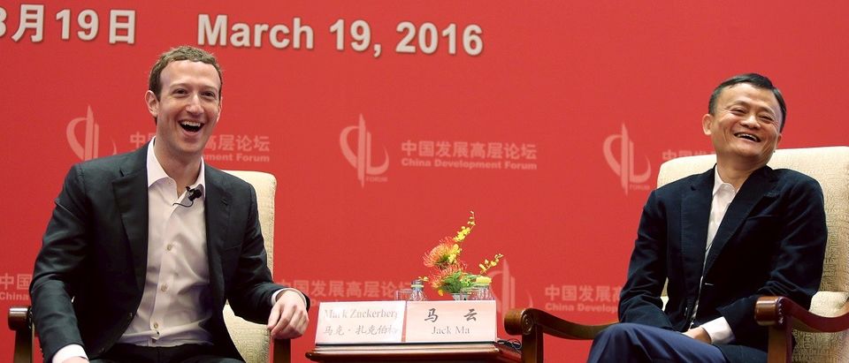 Facebook founder and CEO Mark Zuckerberg and Founder and Executive Chairman of Alibaba Group Jack Ma laugh as they meet at the China Development Forum in Beijing