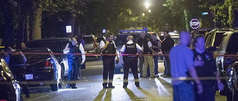 CHICAGO, IL - SEPTEMBER 28: Police officers investigate a shooting scene where 5 people were reported to have been shot, including an 11-month-old infant, on September 28, 2015 in Chicago, Illinois. Chicago, like many major cities in the United States, has experienced a surge in shootings this year. (Photo by Scott Olson/Getty Images)