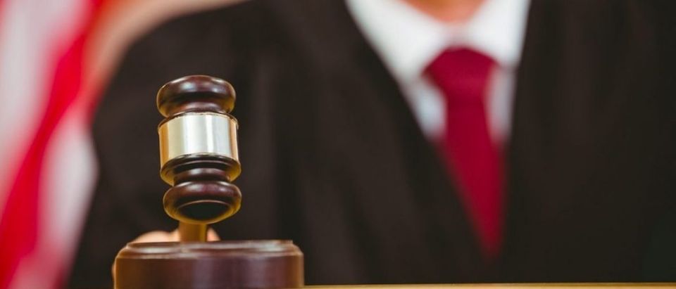 Judge slams a gavel in the court room. (Shutterstock)