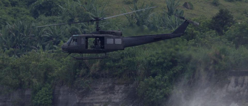 Huey helicopter hovers as U.S. marines patrol during Philippines-U.S.combine arms live fire exercise at Crow Valley in Tarlac city