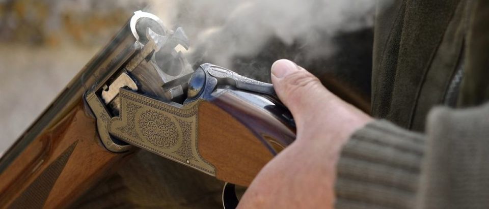 A smoking 12 bore shotgun having ejected spent a cartridge