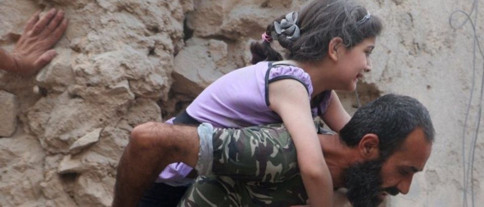 A man carries an injured girl after an airstrike on Aleppo's rebel held Kadi Askar area