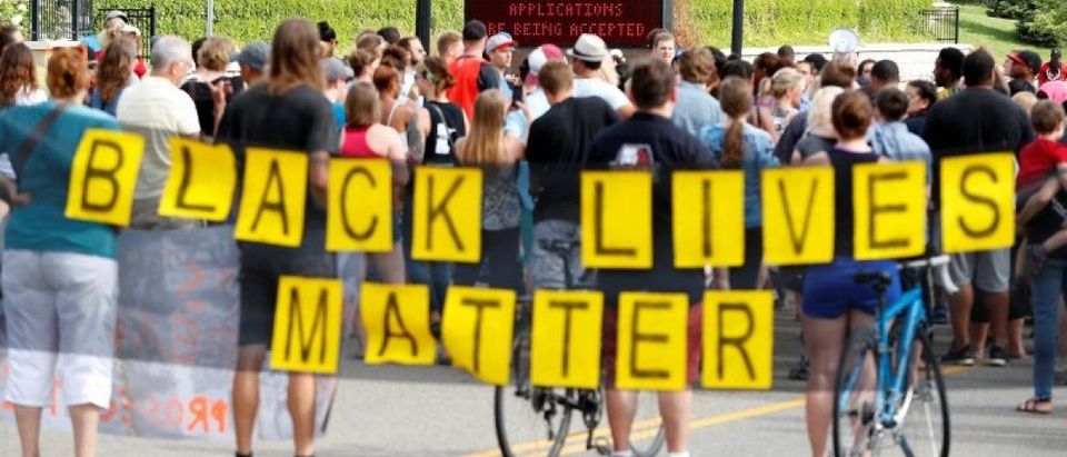 Demonstrators carry a "Black Lives Matter" banner and protest the shooting death of Philando Castile as they gather in front of the police department in St Anthony, Minnesota, U.S., July 10, 2016. REUTERS/Adam Bettcher