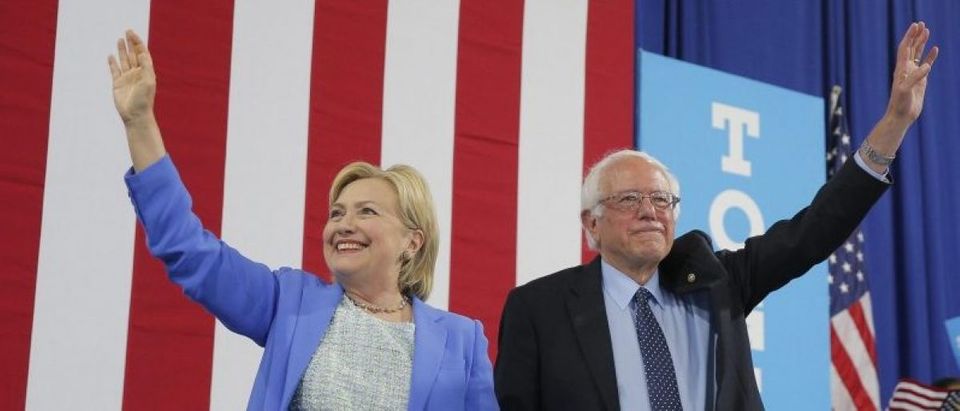 Democratic U.S. presidential candidates Clinton and Sanders stand together during campaign rally in Portsmouth, New Hampshire