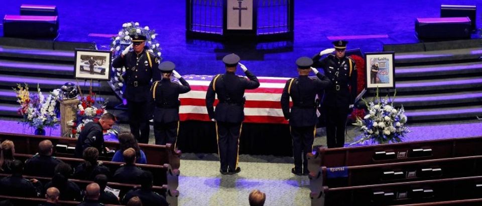 Police officers pay their respects ahead of the funeral for Officer Lorne Ahrens in Plano, Texas, U.S. July 13, 2016. Five officers, including Ahrens, were killed in a shooting incident in Dallas July 7. REUTERS/Carlo Allegri