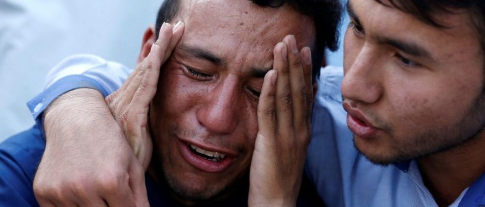 An Afghan man weeps outside a hospital after a suicide attack in Kabul, Afghanistan