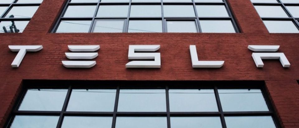 A Tesla logo hang on a building outside of a Tesla dealership in New York, U.S., April 29, 2016. REUTERS/Lucas Jackson