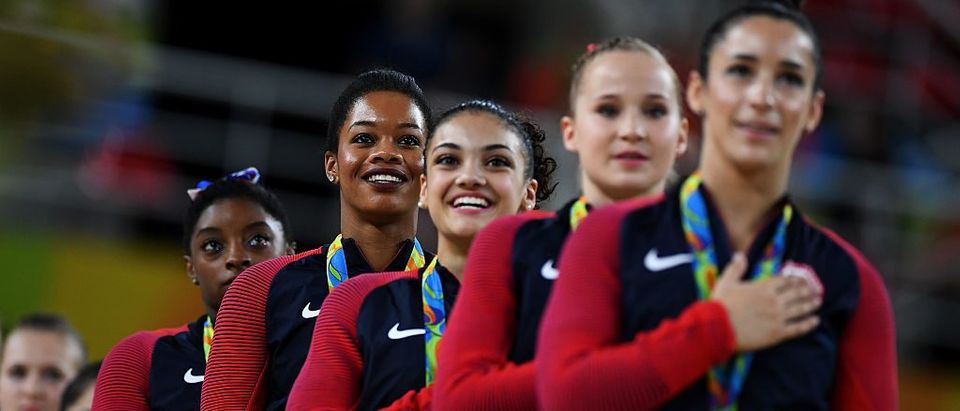 Gold Medalists Simone Biles, Gabrielle Douglas, Lauren Hernandez, Madison Kocian and Alexandra Raisman of the United States stand on the podium for the national anthem at the medal ceremony for the Artistic Gymnastics Women's Team Final on Day 4 of the Rio 2016 Olympic Games at the Rio Olympic Arena on August 9, 2016 in Rio de Janeiro, Brazil