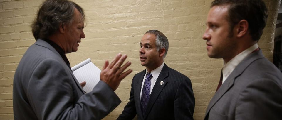 Rep. Huelskamp listens to questions from reporters about House Majority Leader Eric Cantor's Republican primary election defeat in a hallway of the U.S. Capitol in Washington