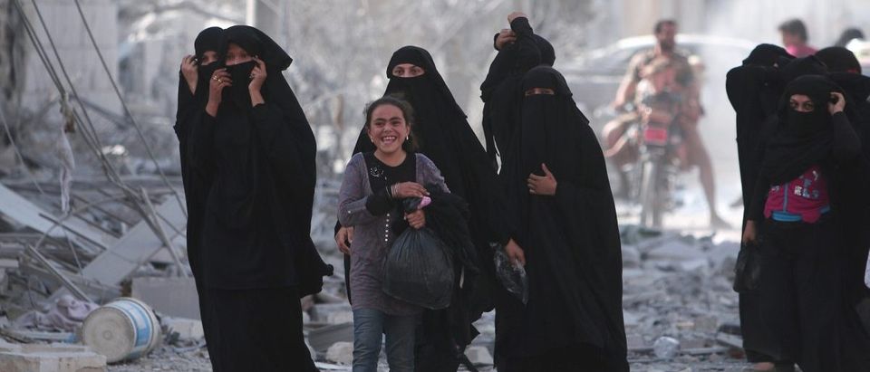 A girl reacts while walking with women after they were evacuated with others by the Syria Democratic Forces (SDF) fighters from an Islamic State-controlled neighborhood of Manbij (Reuters Pictures)
