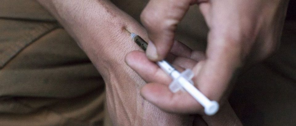 A man injects himself with heroin using a needle obtained from the People's Harm Reduction Alliance, the nation's largest needle-exchange program, in Seattle, Washington April 30, 2015. The People's Harm Reduction Alliance launched its free meth pipe program, which is pioneering but illegal, in March after learning from its own survey that 80 percent of area meth users would be less likely to inject drugs if given access to pipes. The theory behind the Alliance's handout program is that giving meth pipes to drug users may steer some away from needles, which are far riskier than smoking, especially if the user is sharing with another person infected with HIV or hepatitis C. There is little scientific evidence to support that claim, but the Alliance, a privately funded needle-swap group run by drug users, said it has distributed more than 1,000 pipes in Seattle in a matter of weeks and could expand to other cities in Washington state and Oregon. Opponents say giving away meth pipes discourages quitting while wasting resources on an untested scheme that will not solve a city-wide health problem. Picture taken April 30, 2015. REUTERS/David Ryder