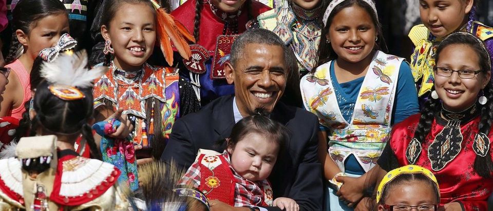 U.S. President Obama holds a baby as he poses with children at Cannon Ball Flag Day Celebration in Standing Rock Sioux Reservation in North Dakota
