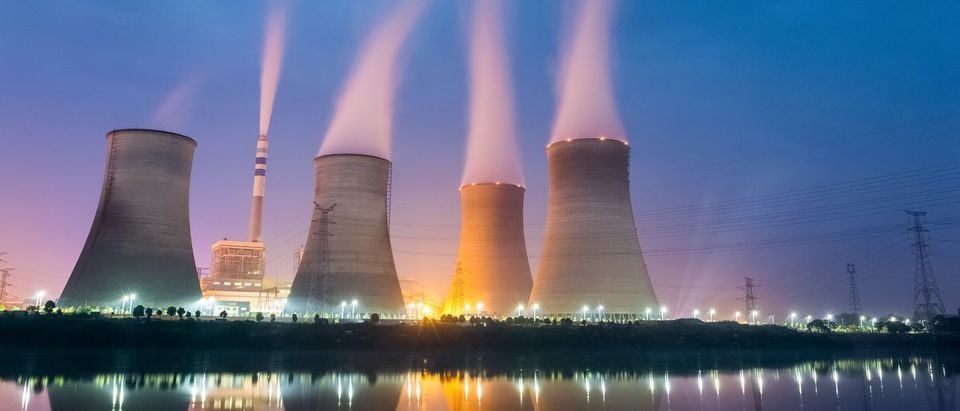 Nuclear reactors at night , cooling tower closeup with steam.(Shutterstock/chuyuss)